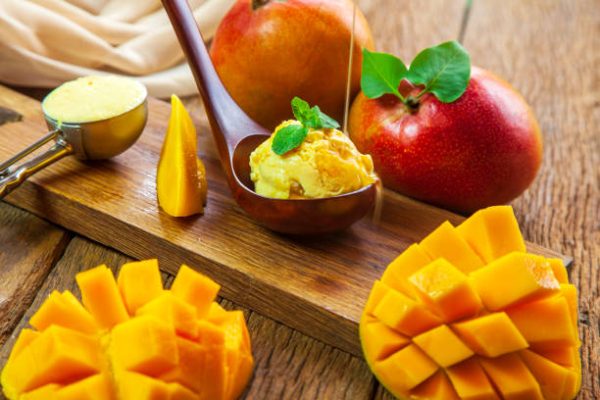 ice cream with mango pulp, garnished with mint, on wooden background