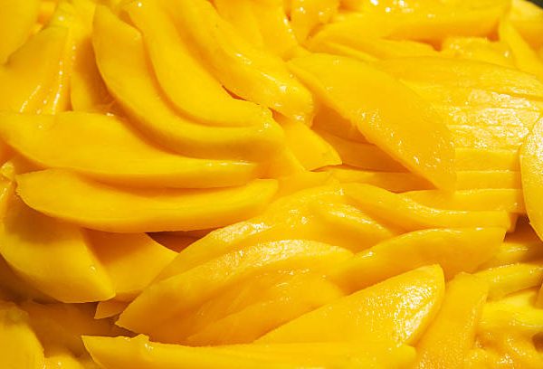 Fresh Mango slices as a background.