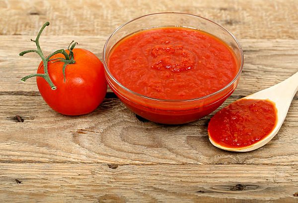 bowl of tomato paste on wooden surface